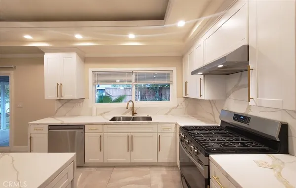 a kitchen with stainless steel appliances a sink stove and cabinets