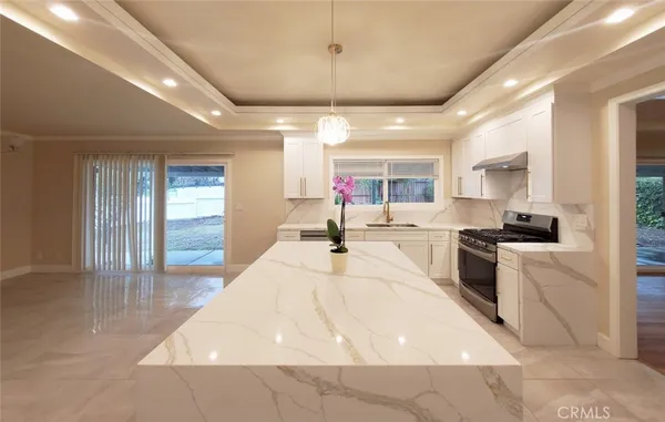 a living room with stainless steel appliances kitchen island furniture and a kitchen view