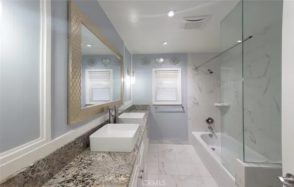 a spacious bathroom with a granite countertop tub shower sink and mirror