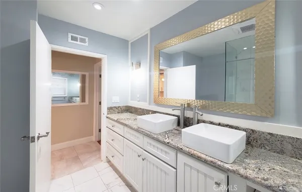a bathroom with granite countertop a sink and a mirror