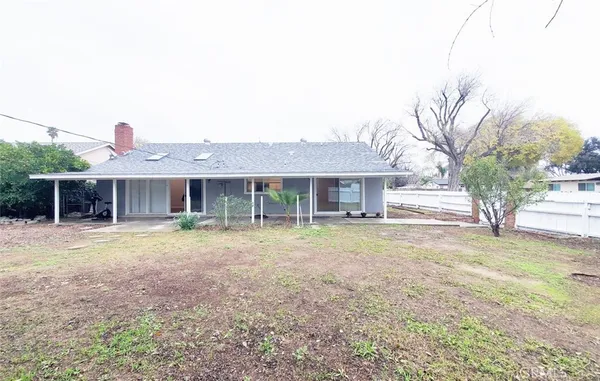 a front view of a house with a garden and trees