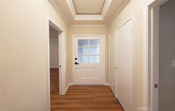 a view of a hallway with wooden floor and a bathroom