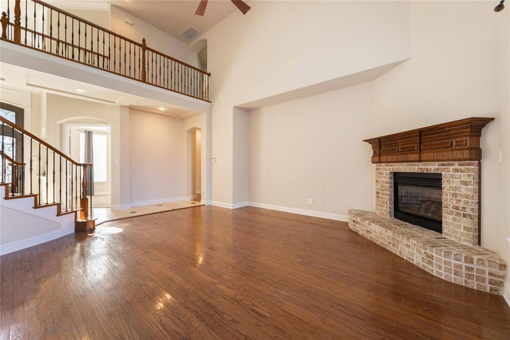 2009 Briarbrook Lane Allen, TX 75002 - Photo 12 of 40 an empty room with wooden floor fireplace and windows