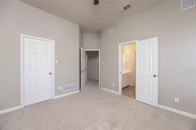 an empty room with ceiling fan and window