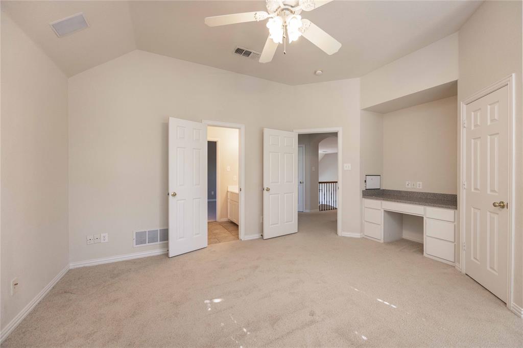 2009 Briarbrook Lane Allen, TX 75002 - Photo 25 of 40 Unfurnished bedroom with built in study area, light colored carpet, ensuite bath, lofted ceiling, and a ceiling fan