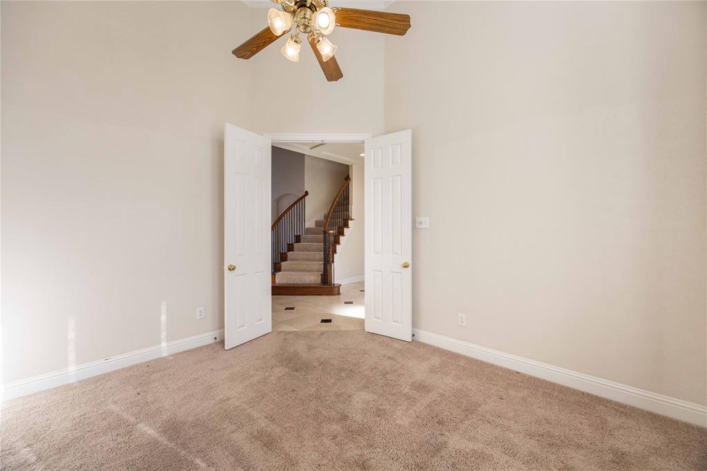 2009 Briarbrook Lane Allen, TX 75002 - Photo 3 of 40 Empty room featuring a towering ceiling, carpet floors, and a ceiling fan