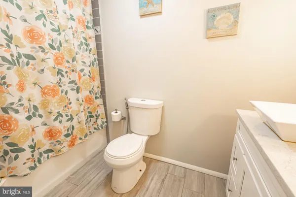 a kitchen with a sink dishwasher a stove a microwave oven and a dining table with wooden floor