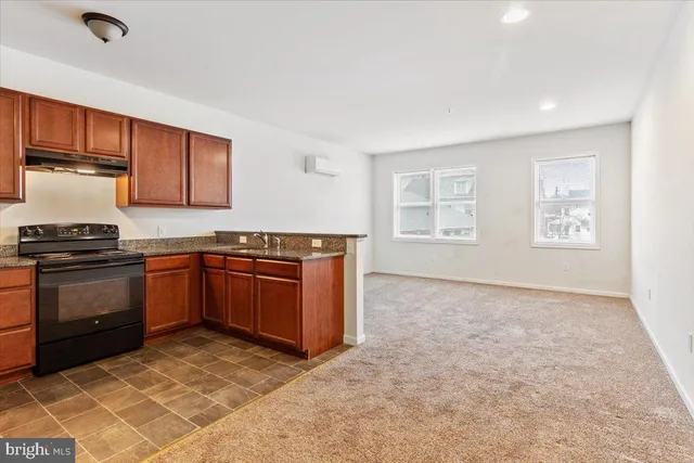 a kitchen with stainless steel appliances granite countertop a stove a sink and a refrigerator