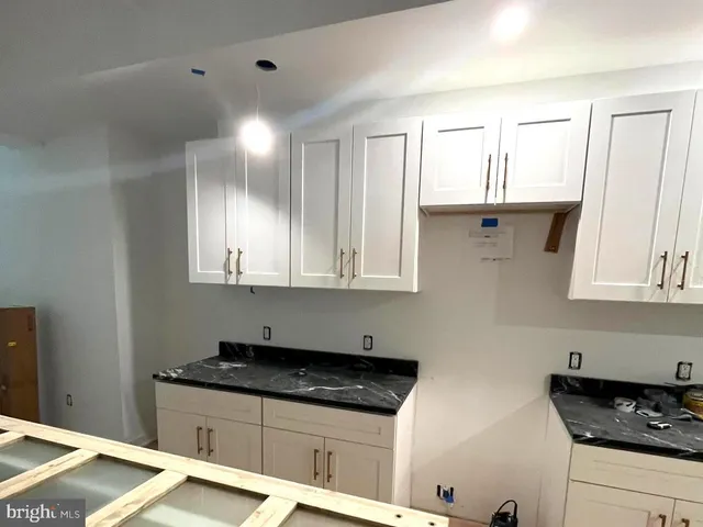 a kitchen with granite countertop a sink and cabinets
