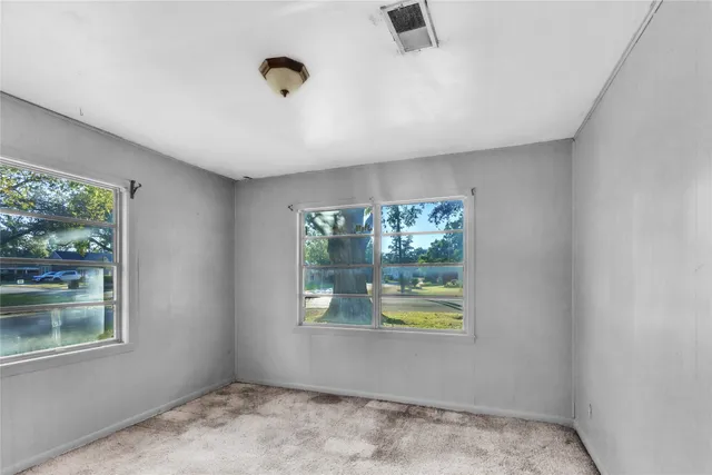 an empty room with windows and closet