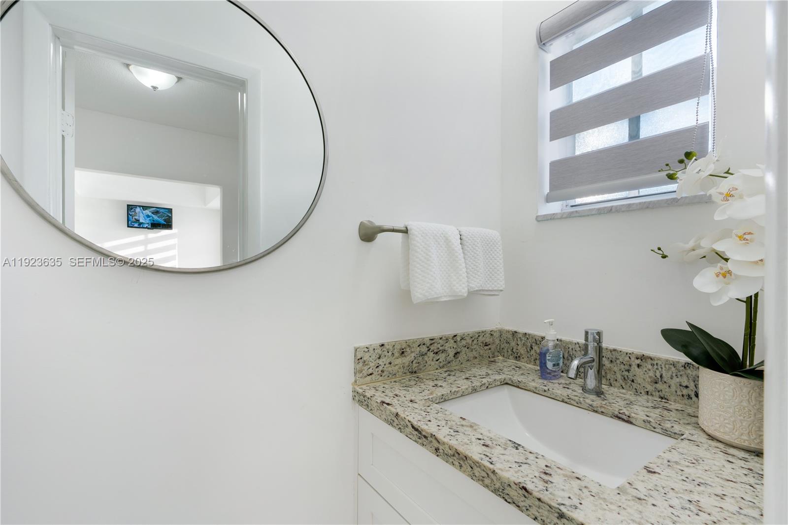 9167 Harding Avenue, Unit 9167 Surfside, FL 33154 - Photo 12 of 45 a bathroom with a granite countertop sink and a mirror