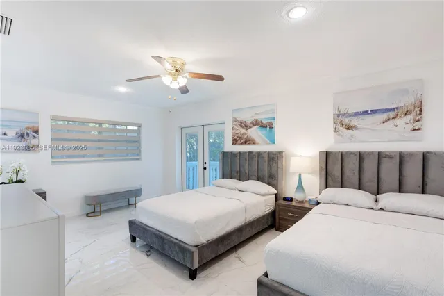 a bedroom with two beds and a painting on the wall