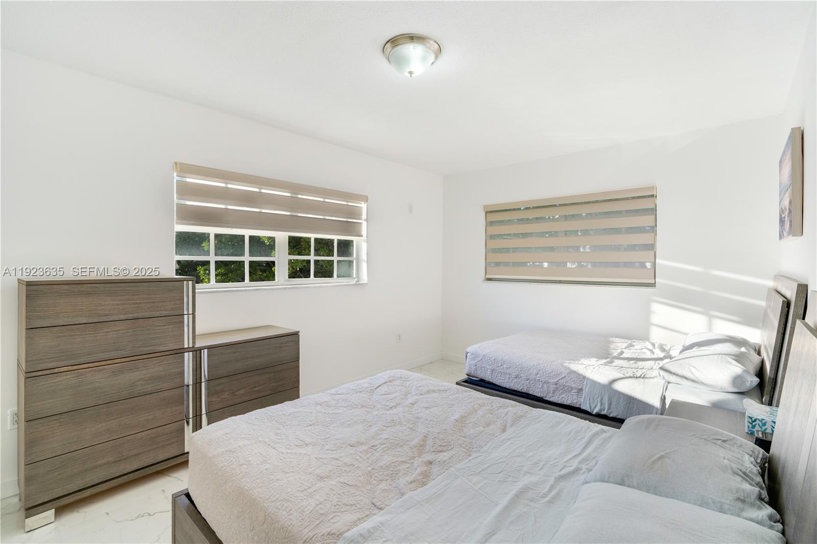 9167 Harding Avenue, Unit 9167 Surfside, FL 33154 - Photo 23 of 45 a bedroom with a bed and a dresser