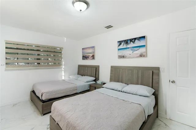 a bedroom with two beds and painting on the wall