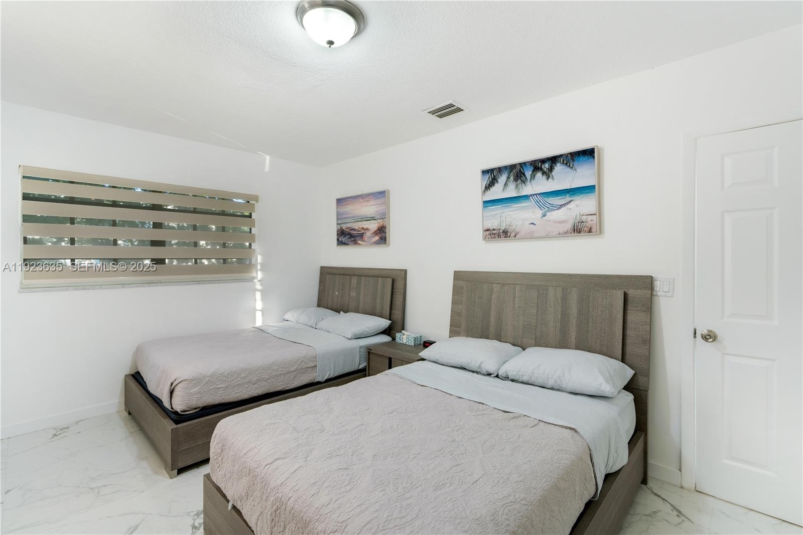 9167 Harding Avenue, Unit 9167 Surfside, FL 33154 - Photo 24 of 45 a bedroom with two beds and painting on the wall