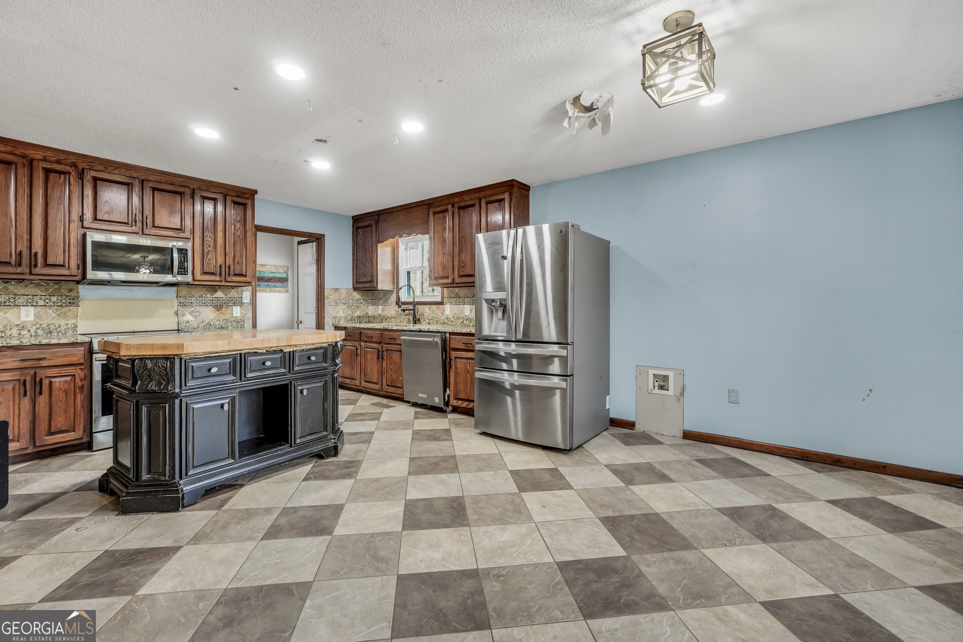 119 Bagley Road Forsyth, GA 31029 - Photo 11 of 36 a kitchen with stainless steel appliances granite countertop a stove a sink and a refrigerator