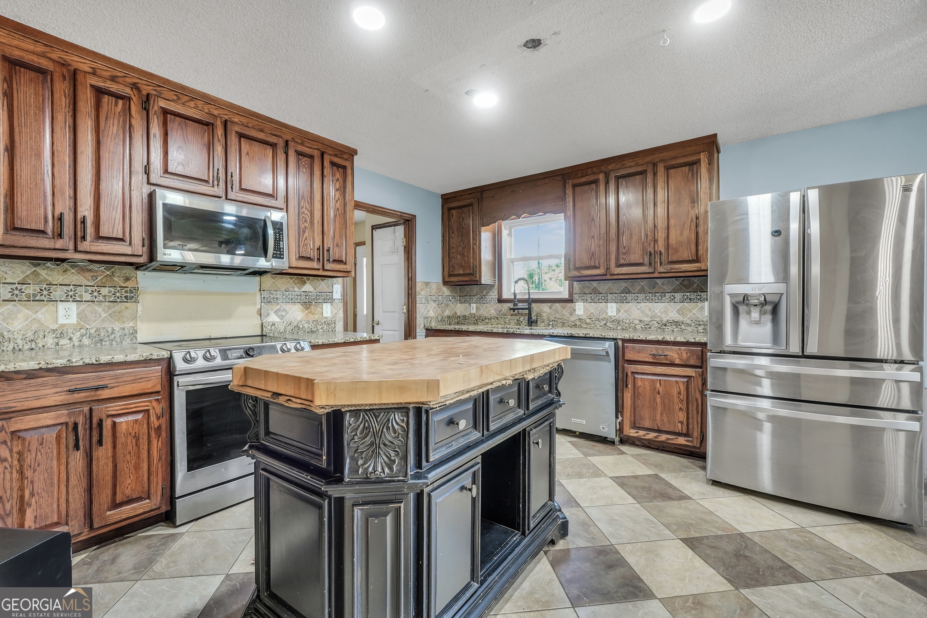 119 Bagley Road Forsyth, GA 31029 - Photo 12 of 36 a kitchen with stainless steel appliances granite countertop a stove a sink dishwasher a refrigerator and a microwave
