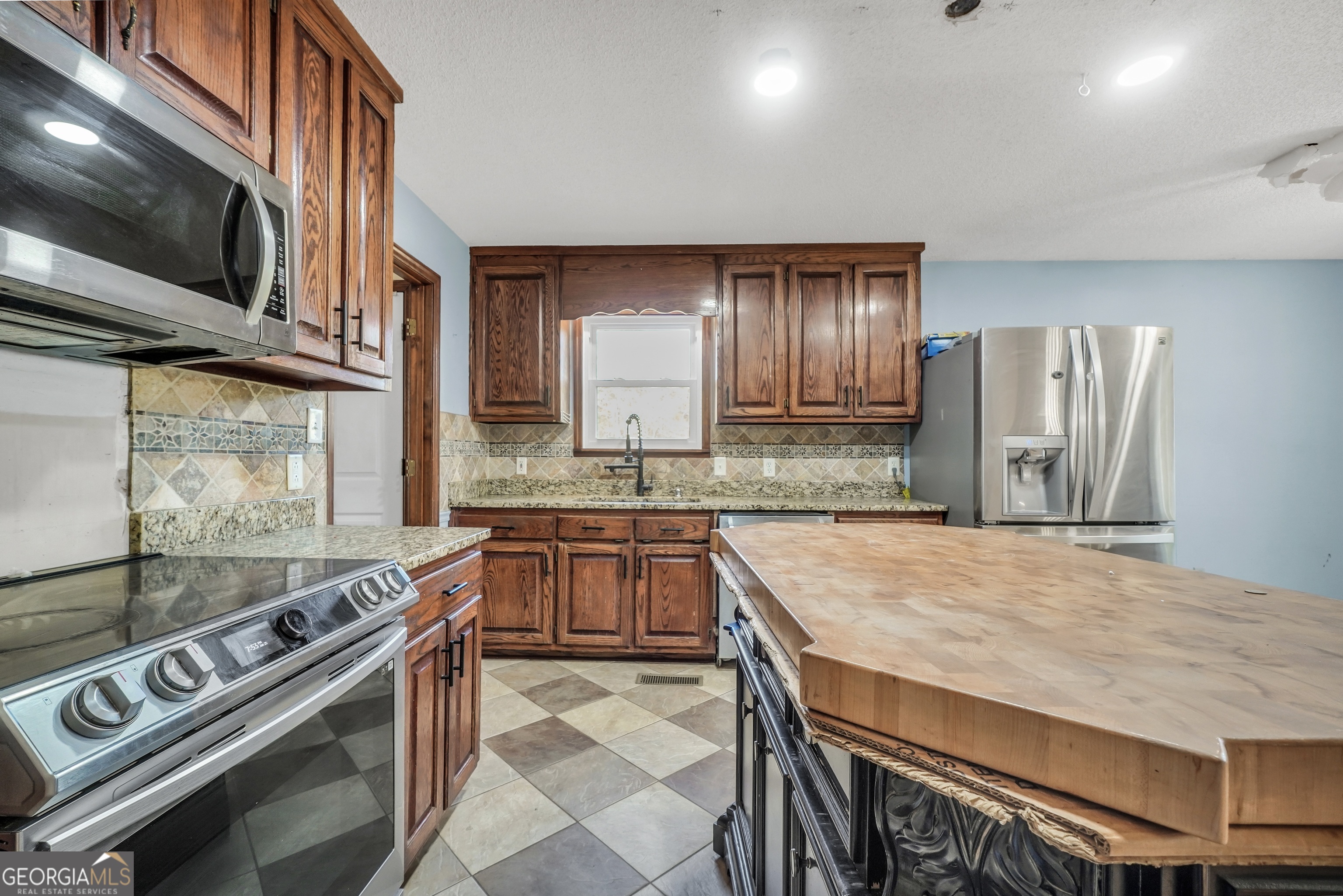 119 Bagley Road Forsyth, GA 31029 - Photo 14 of 36 a kitchen with stainless steel appliances granite countertop a stove and a sink