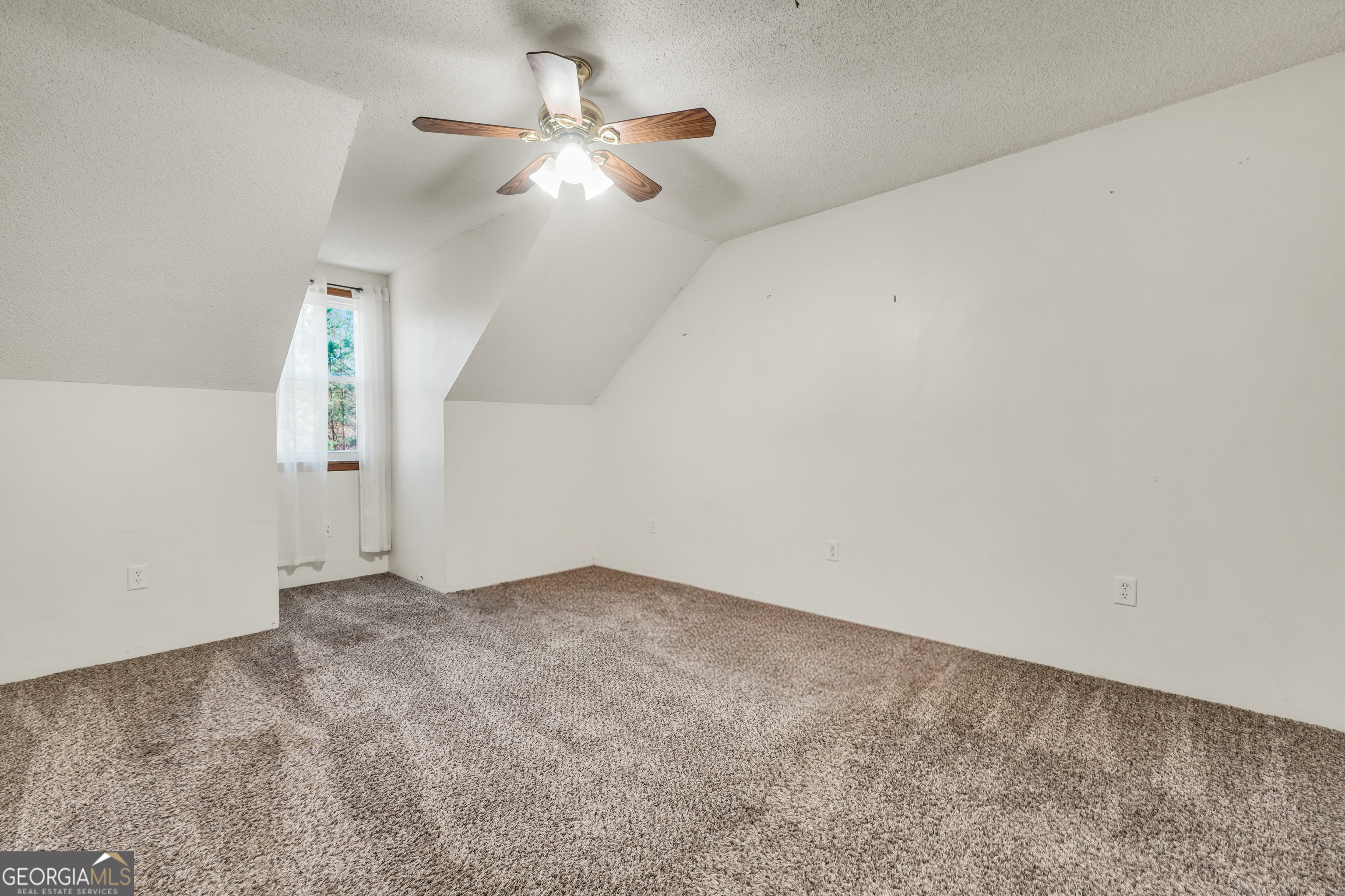 119 Bagley Road Forsyth, GA 31029 - Photo 27 of 36 an empty room with a chandelier fan and wooden floor