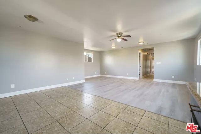 an empty room with fan and a chandelier fan