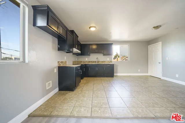 a large kitchen with stainless steel appliances granite countertop a stove a sink and a refrigerator