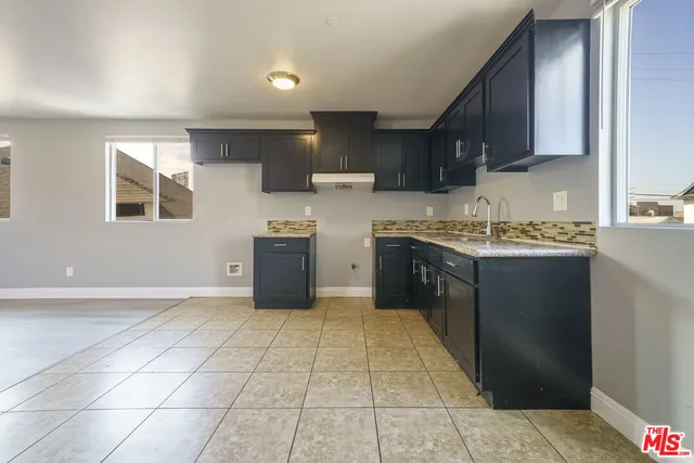 a kitchen with stainless steel appliances granite countertop a sink stove and cabinets