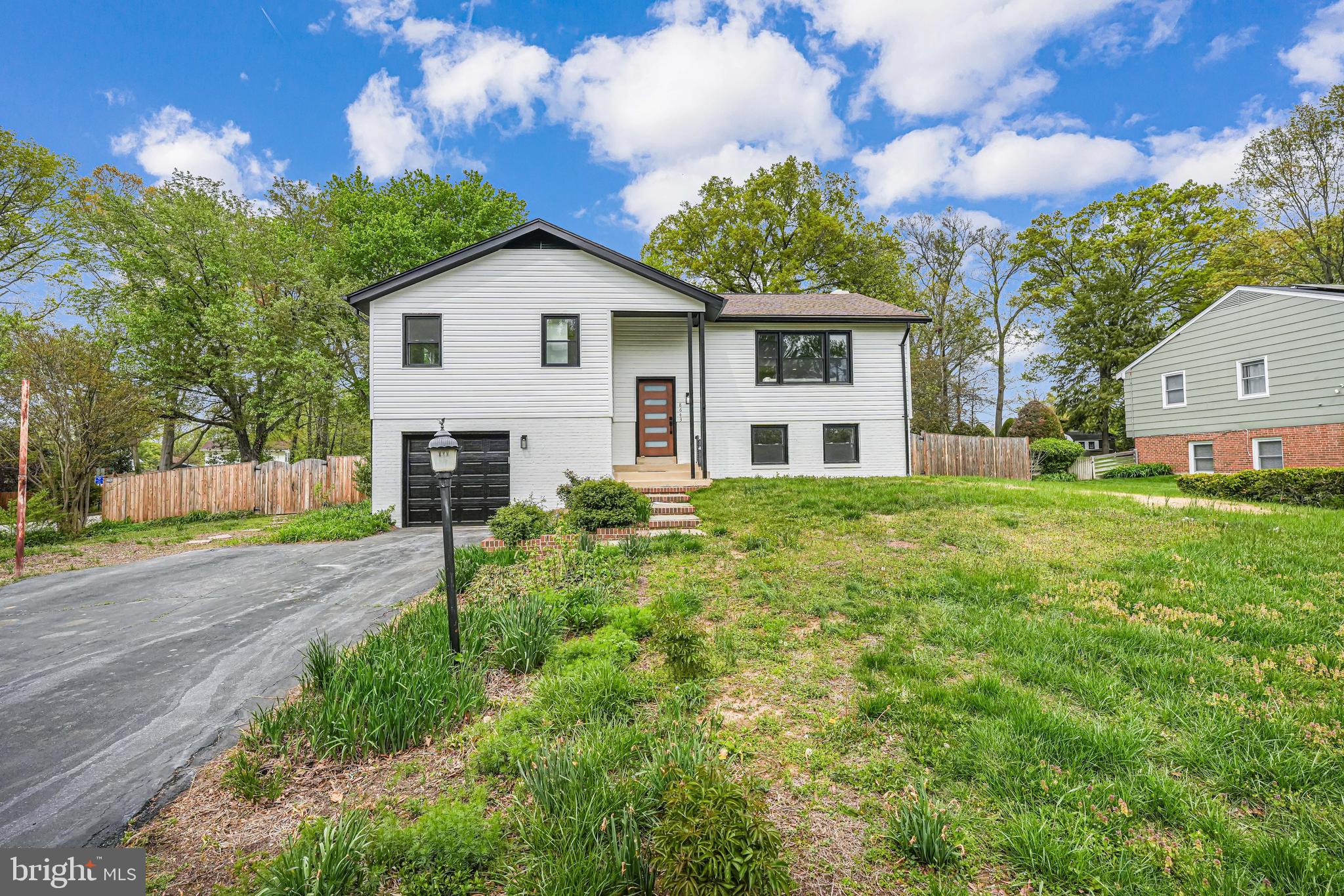 a view of a yard in front of a house with large trees