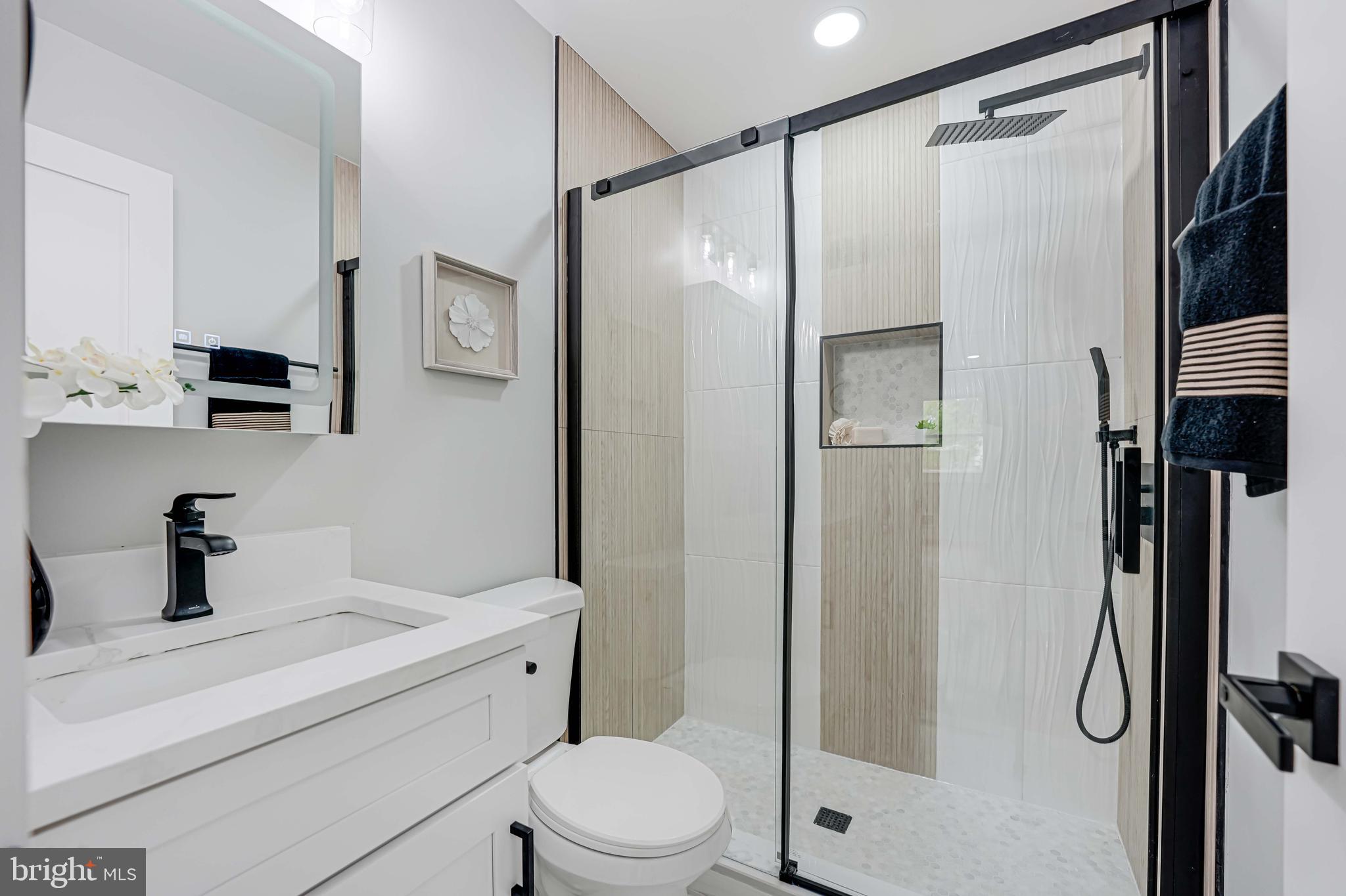 8643 Gateshead Road Alexandria, VA 22309 - Photo 23 of 40 a bathroom with a shower sink vanity mirror and toilet