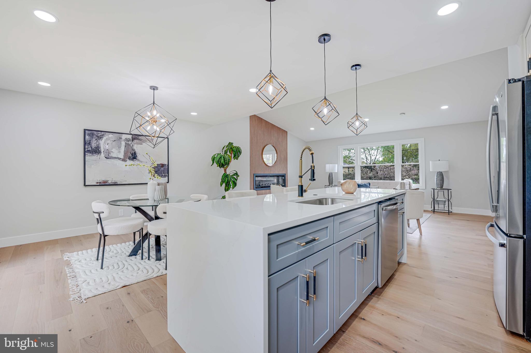 8643 Gateshead Road Alexandria, VA 22309 - Photo 10 of 40 a large kitchen with kitchen island a flat screen tv and a chandelier