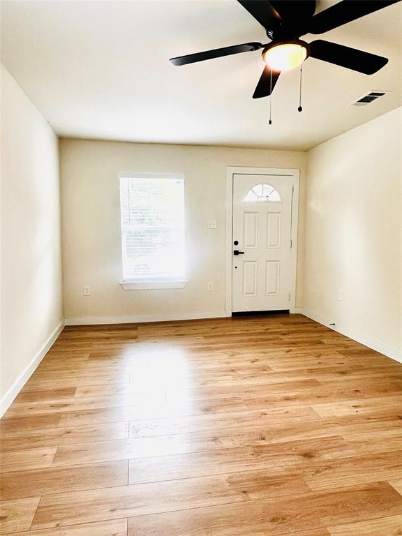 3719 Meadow Street Dallas, TX 75215 - Photo 13 of 18 a view of an empty room with window and wooden floor