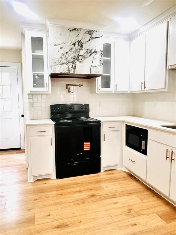 3719 Meadow Street Dallas, TX 75215 - Photo 6 of 18 a kitchen with stainless steel appliances a stove a microwave and white cabinets