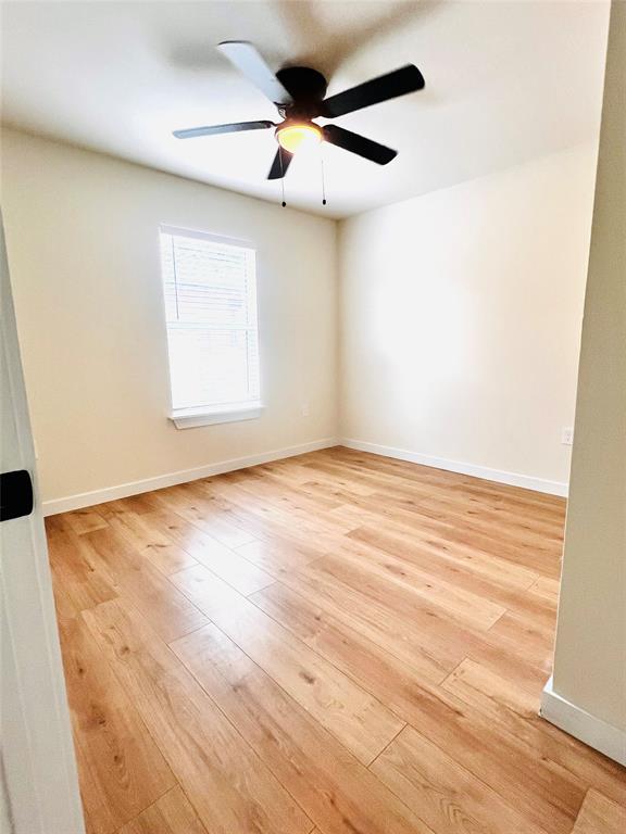 3719 Meadow Street Dallas, TX 75215 - Photo 9 of 18 an empty room with wooden floor and windows