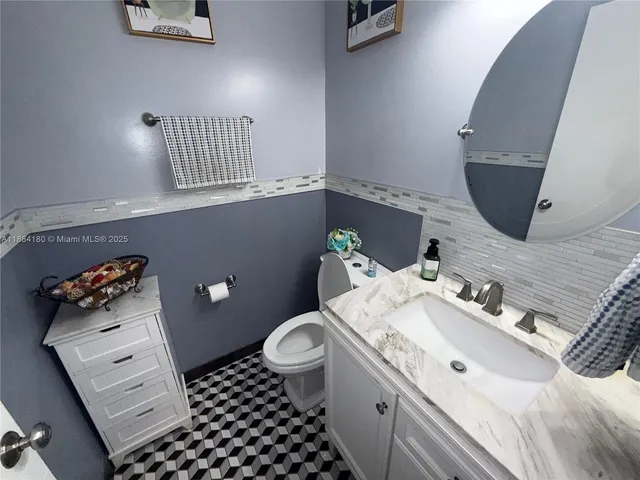 a bathroom with a sink mirror and toilet