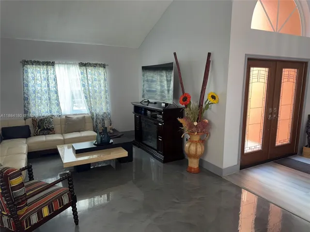 a living room with furniture a window and gym equipment