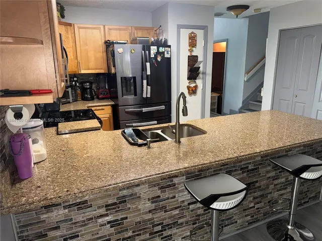 a kitchen with stainless steel appliances granite countertop a stove a sink and a refrigerator