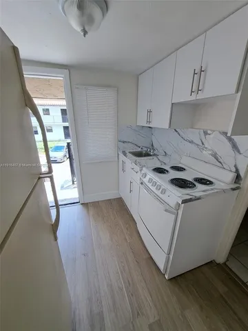 a kitchen with a stove a sink and a refrigerator