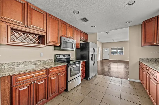 a kitchen with stainless steel appliances granite countertop a refrigerator and a stove top oven