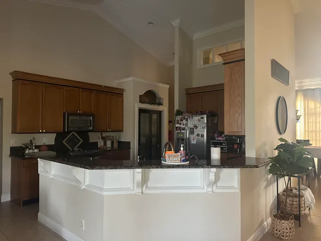 a kitchen with stainless steel appliances granite countertop a sink refrigerator and microwave