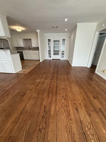 a open kitchen with kitchen island a sink dishwasher and a stove with wooden floor