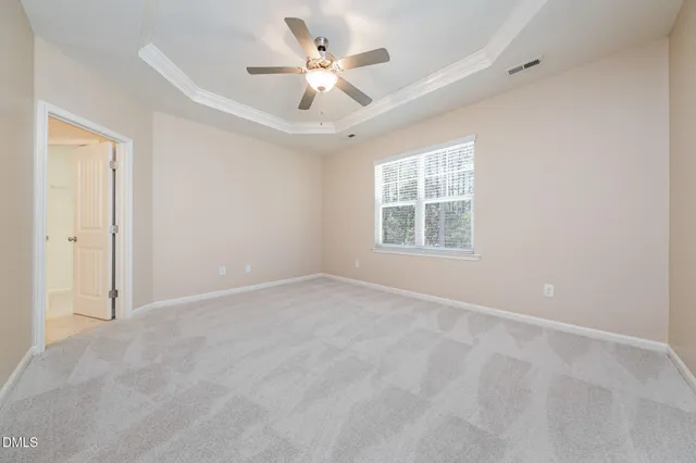 an empty room with windows and ceiling fan