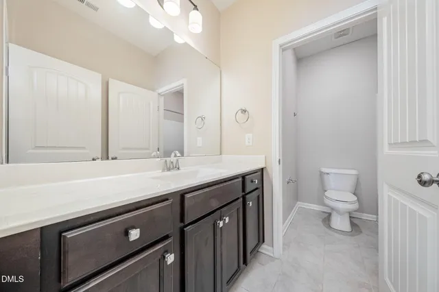 a bathroom with a sink a toilet and a mirror