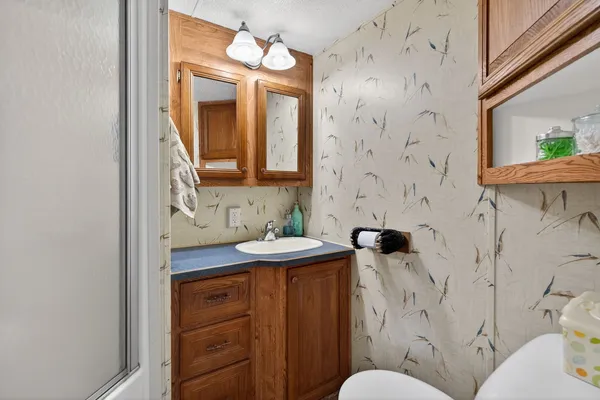 a bathroom with a granite countertop sink mirror and toilet