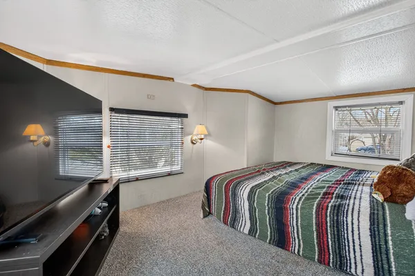 a bed sitting in a bedroom next to a window