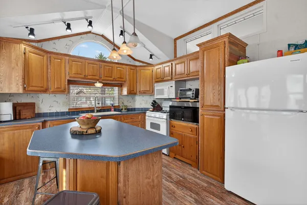 a kitchen with a refrigerator a stove a sink dishwasher and cabinets with wooden floor