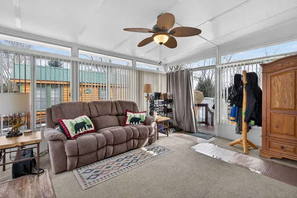 a living room with furniture a ceiling fan and a window