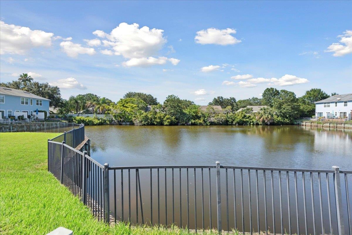 a balcony with outdoor space lake view and houses in the back