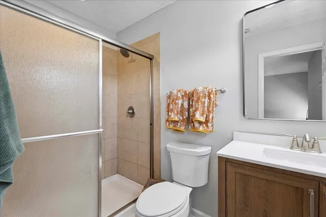 a bathroom with a sink a toilet a shower and a mirror