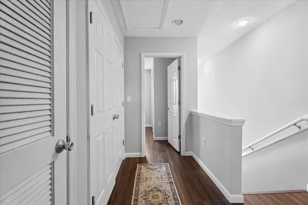 a view of a hallway with wooden floor and staircase