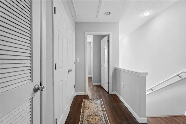 a view of a hallway with wooden floor and staircase