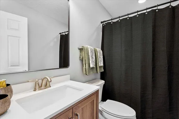 a bathroom with a sink vanity mirror and toilet